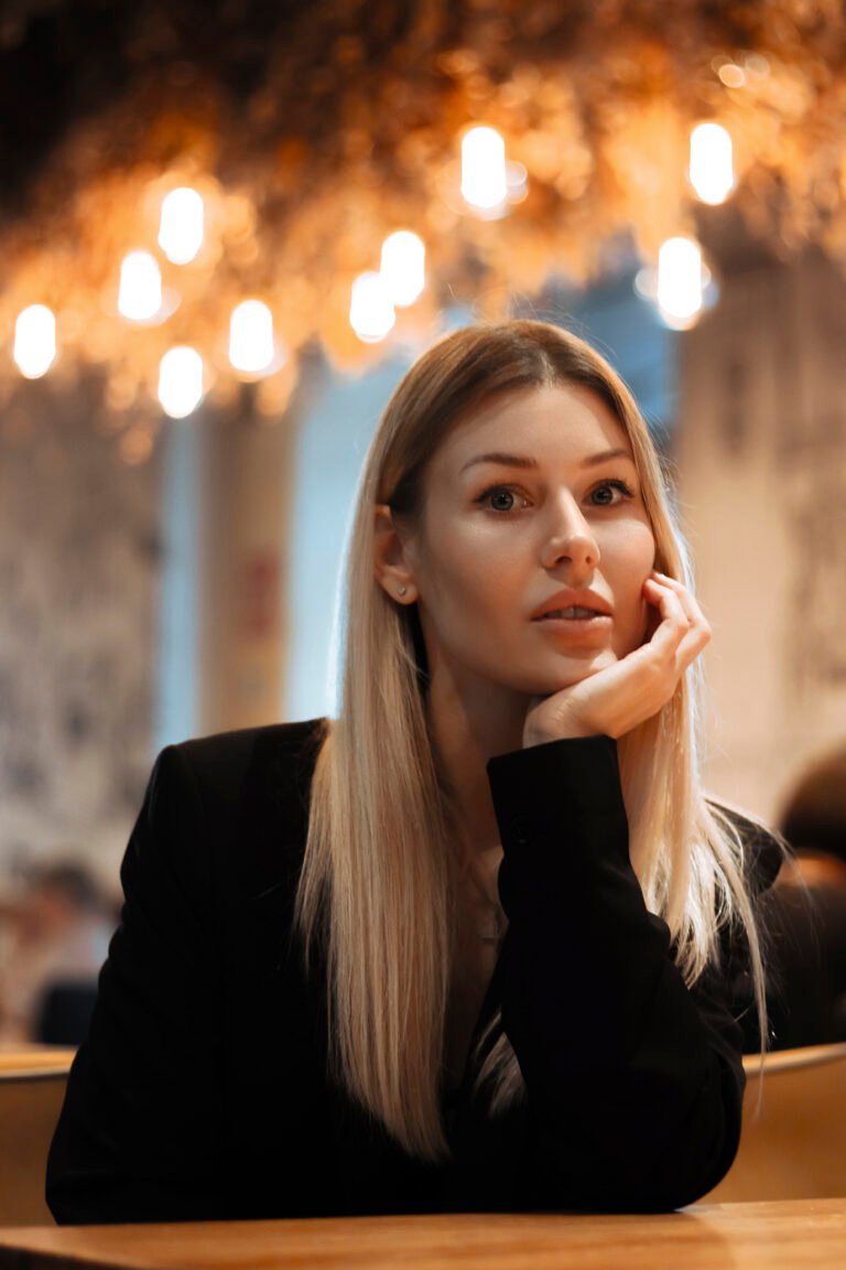 Жінка з маленьким іменинним тістечком у кафе