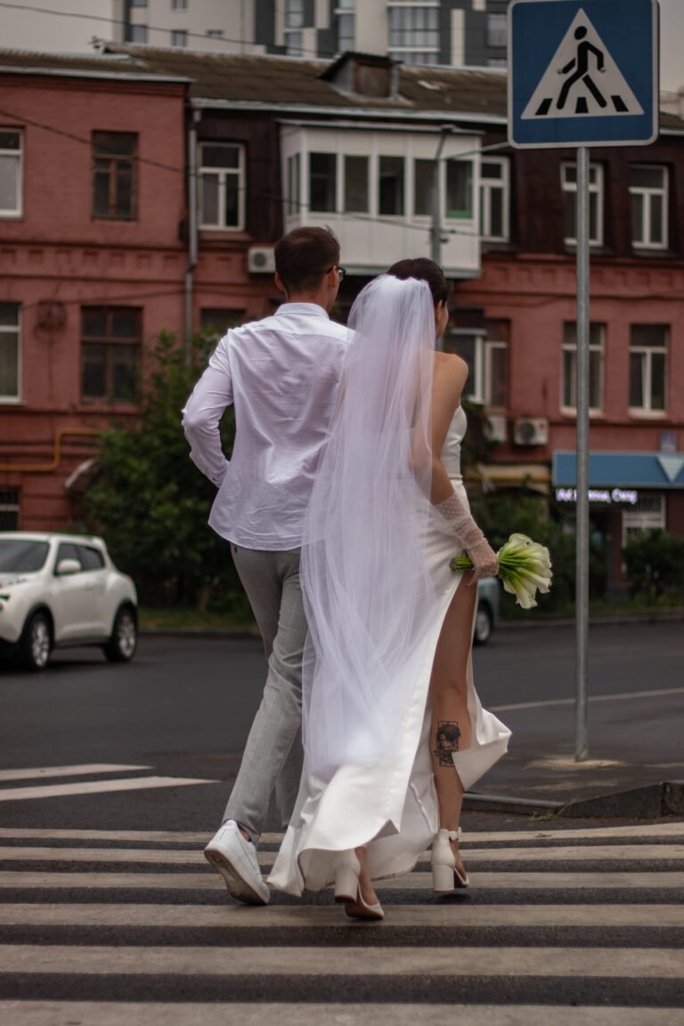 Молодята під час прогулянки мокрою міською вулицею