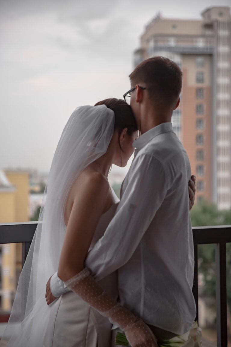 Молодята обіймаються біля вікна